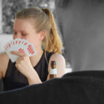 Bild vom Skatturnier 2021. Eine junge Frau lächelt und hält Karten.